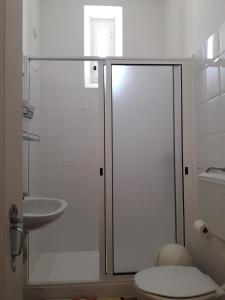 a bathroom with a shower and a toilet and a sink at Pensao Residencial Mirasol in Funchal