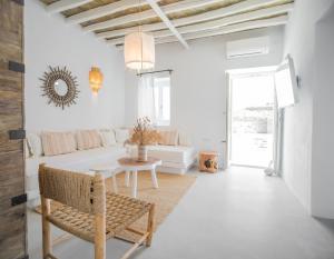 a white living room with a table and a couch at Makarias Traditional Luxury Villas in Ano Meria
