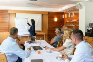 a group of people sitting at a table in a meeting at Apartmány Engadin in Boží Dar +70 photos