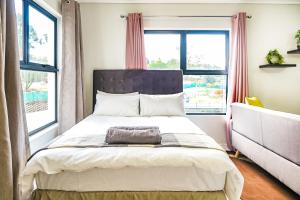 - une chambre avec un lit et 2 fenêtres dans l'établissement Insaka's Greenlee Apartment - Greenlee Lifestyle Centre, Sandton, à Sandown