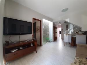 a living room with a flat screen tv on a wall at Serra Mar Suítes,Lofts, e casas à 300 metros das praias in Arraial do Cabo