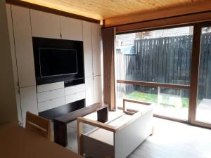 sala de estar con TV, mesa y sillas en MONOAMBIENTE en San Martín de los Andes