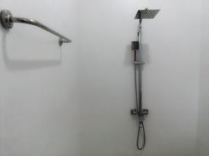 a shower with a shower head on a wall at The Nest in Tangalle