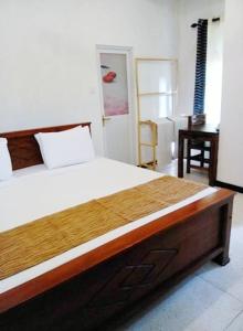 una camera da letto con un letto e una scrivania in una stanza di The Nest a Tangalle