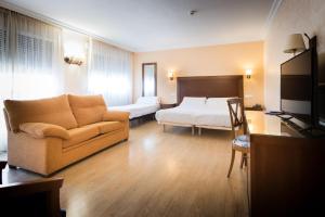 a hotel room with a couch and a bed at Abadía Burgos Camino Santiago in Burgos