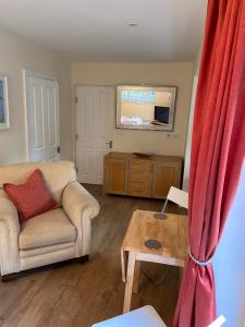 a living room with a couch and a table at The Garden Room in Ipswich