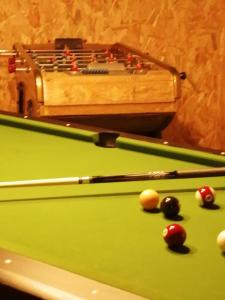 a green pool table with balls and a box at Villa bord de mer avec piscine et jacuzzi in Pénestin
