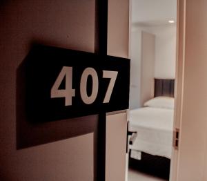 eine Uhr an einer Tür in einem Zimmer mit einem Bett in der Unterkunft Loft com vista para Vila Germânica 407 in Blumenau