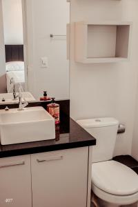 uma casa de banho com um WC branco e um lavatório. em Loft com vista para Vila Germânica 407 em Blumenau