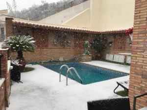 ein Schwimmbad in einem Hof mit Schnee in der Unterkunft Apartamentos Turísticos Tronca Luxury in Granada