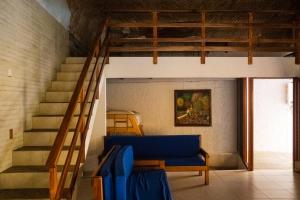 a living room with a blue couch and stairs at Las Casitas in Rincon de Guayabitos