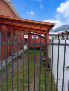 une clôture devant un bâtiment avec un portail dans l'établissement Cabaña Patagonia Rustica, à Coyhaique