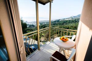 un balcón con una mesa y un bol de fruta. en Lara Apartments, en Makarska