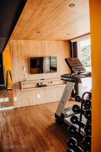 a room with a gym with a television and a treadmill at Loft próximo a Vila Germânica 310 in Blumenau