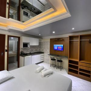 1 dormitorio con 1 cama blanca grande y cocina en Pousada Açoriana, en Florianópolis