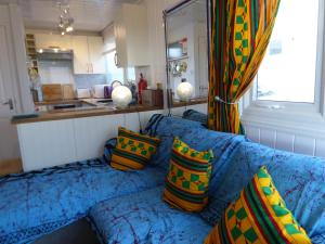 a living room with a blue couch with colorful pillows at Bridlington's Bolt Hole chalet in Bridlington