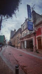 an empty street with a sign on a building at Hotel Enterprise Inn Plaza in León