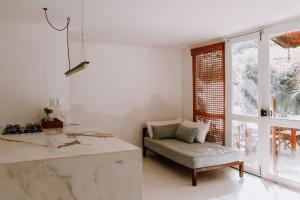 een keuken met een aanrecht, een stoel en een raam bij Qavi - Pipa Atlântico Bungalow 08 in Pipa