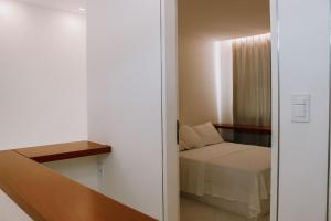 een kleine slaapkamer met een bed en een raam bij Qavi - Pipa Atlântico Bungalow 08 in Pipa