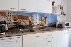 un comptoir de cuisine orné d'une fresque représentant une ville dans l'établissement Apartament urokliwa Długa, à Gdańsk