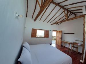 ein Schlafzimmer mit einem weißen Bett in einem Zimmer in der Unterkunft Artepolis in Barichara