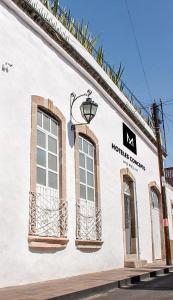 a white building with windows and a street sign at M Hoteles Concepto in Morelia