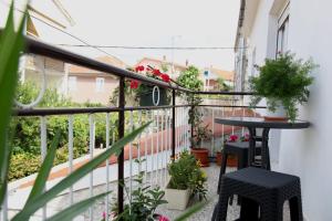 d'un balcon avec une table, des chaises et des plantes. dans l'établissement Apartman Mantenjin, à Trogir
