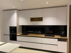 a kitchen with white cabinets and a black appliance at Splendor in the forest in Braşov