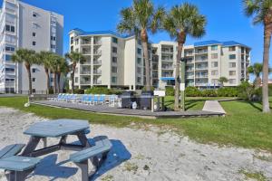 a picnic table on the beach in front of a building at Caprice Resort by Travel Resort Services in St. Pete Beach