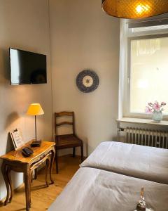 a bedroom with a bed and a table with a lamp at Ferienwohnung Dom- u. Regnitzblick in Bamberg