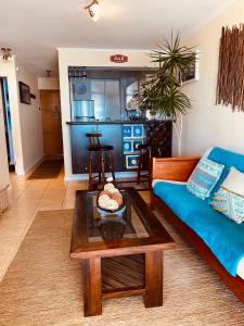 a living room with a blue couch and a table at Departamento La Serena Avenida Del Mar in La Serena