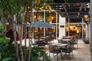 a patio area with tables, chairs and umbrellas at Hotel Contessa -Suites on the Riverwalk in San Antonio