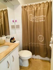 y baño con aseo y cortina de ducha. en Departamento La Serena Avenida Del Mar en La Serena