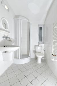 biała łazienka z umywalką i toaletą w obiekcie Hotel U Jezírka w mieście Liberec
