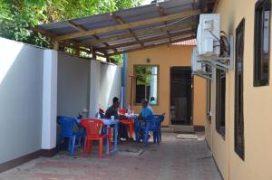 two people sitting at a table under a pergola at Lunguya Lodge in Dar es Salaam