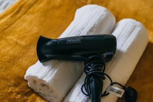 a black hair dryer sitting on top of towels at Skelton house - Short stay leeds in Leeds +16 photos