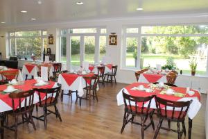 a dining room with red and white tables and chairs at The Dial House Guest House in Oxford