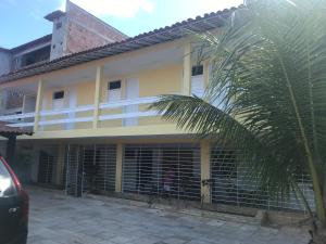 ein gelbes Gebäude mit einer Palme davor in der Unterkunft Casa temporada Tamandaré Carneiros in Tamandaré