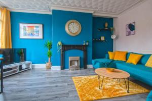 a living room with blue walls and a blue couch at Skelton house - shortstayleeds in Leeds