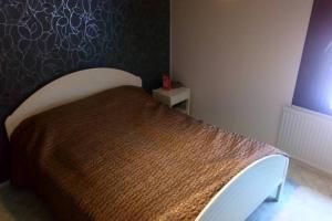 1 dormitorio con 1 cama con colcha marrón en Kivirannantie 28, en Iisalmi