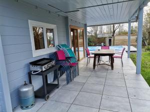 a patio with chairs and a table and a grill at Gîte Ker Koad in Pluduno