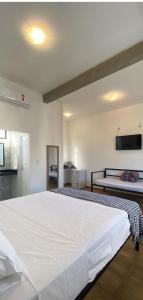 a bedroom with a large white bed in a room at Flor de Mandacaru Pousada in Boqueirão (1)