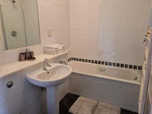 a bathroom with a sink and a bath tub at Stockton Heights, Warrington, Centrally Located Between Town Centre and Stockton Heath, High Speed Wifi, Cozy Stay in Warrington