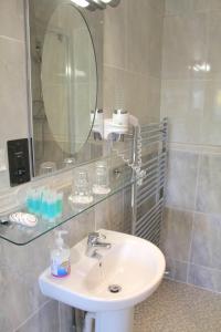 La salle de bains est pourvue d'un lavabo et d'un miroir. dans l'établissement The Dial House Guest House, à Oxford