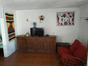 sala de estar con TV y sofá rojo en Flor de Lis Casa, en La Paloma 10 fotos más