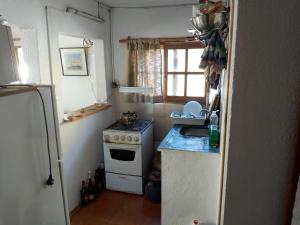 Una pequeña cocina con estufa y refrigerador. en Flor de Lis Casa, en La Paloma