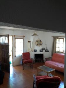 Una sala de estar con un sofá rojo y una chimenea. en Flor de Lis Casa, en La Paloma