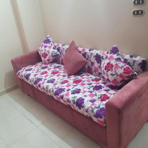 Sweet Home Flat 1 في الغردقة: أريكة عليها وسائد في الغرفة