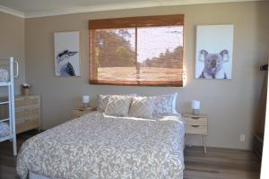 una camera da letto con un letto e una finestra di Rio Rita Ocean View Apartments a Batemans Bay