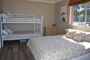 a bedroom with two bunk beds and a window at Rio Rita Ocean View Apartments in Batemans Bay